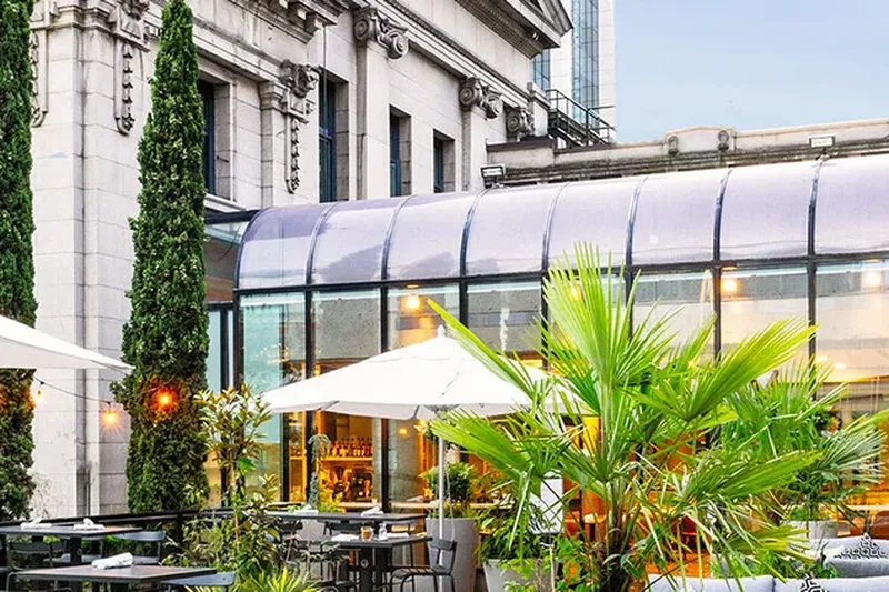 Outdoor tables and umbrellas beside the gallery building at 1931 Gallery Bistro.