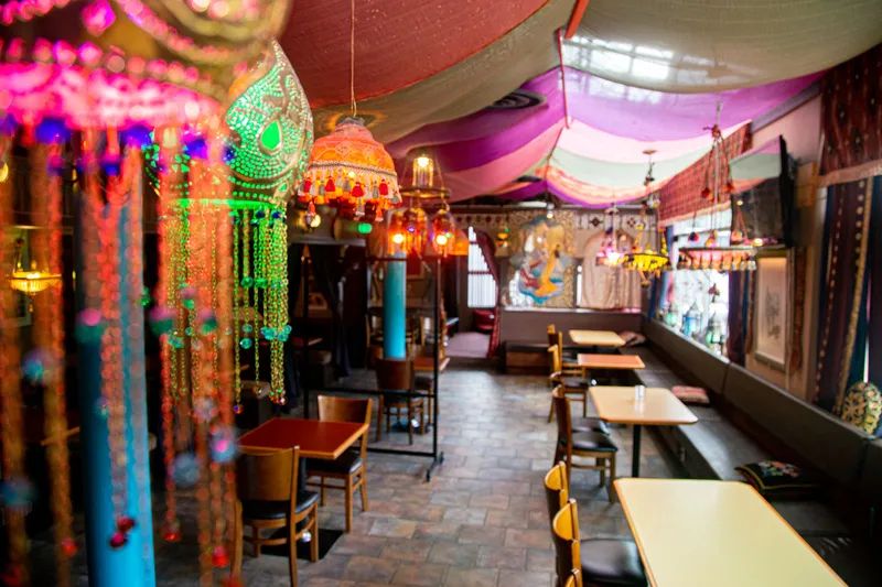 Tables, low seating and colourful draped fabrics inside Afghan Horsemen.