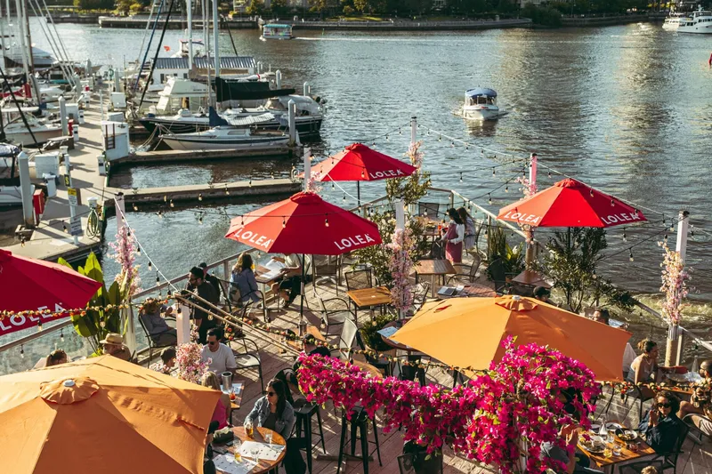 Patio tables and colourful umbrellas overlooking the marina at Baeside.