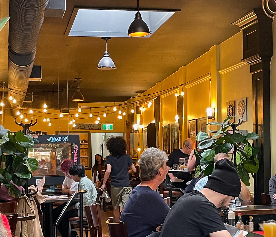 Customers seated beneath string lights in the dining room at Caffe Barney on Granville.