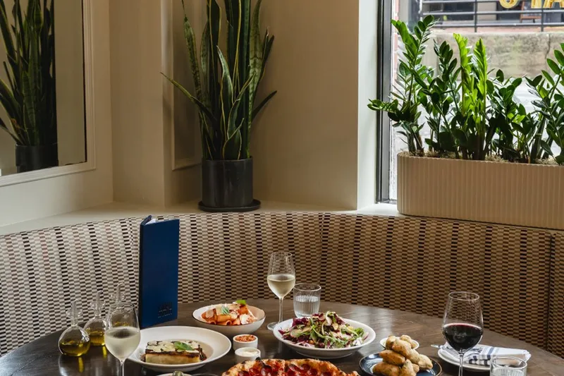 Dishes set on a table beside a window at Capo and Spritz.