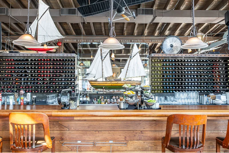 The bar at Cardero’s with bottles and a model sailing ship.