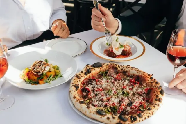 Pizza and other dishes served at a dining table at Acquafarina.