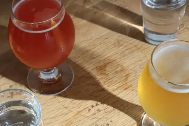 Glasses of colourful drinks on a wooden table at Brewing August.