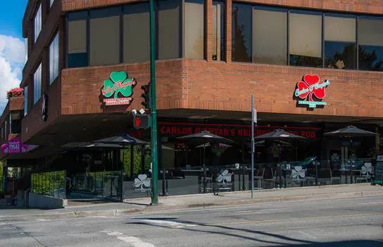 Carlos O'Bryan's Kitsilano exterior with branded shamrock signs and a street-side patio.