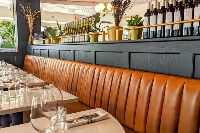 Set tables along the leather banquette at Coquette Brasserie.