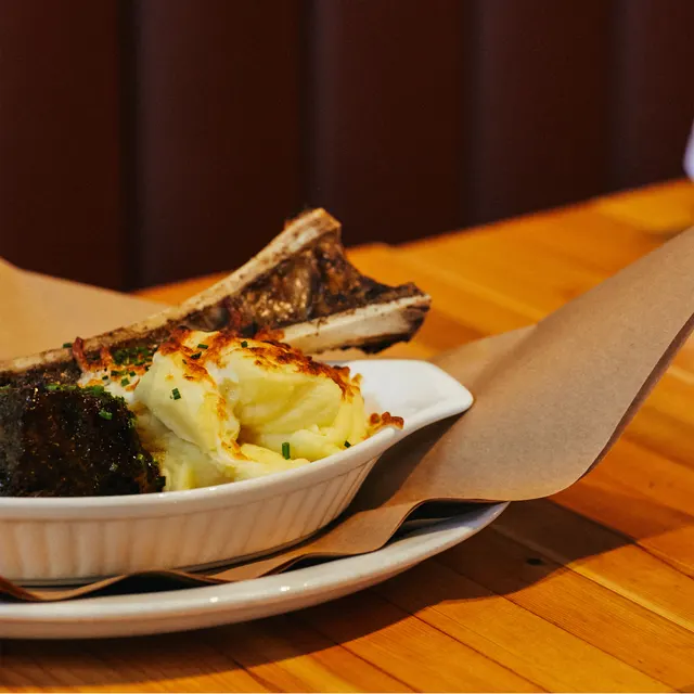 A plated meal with mashed potatoes and roasted bone marrow at The Flying Pig.