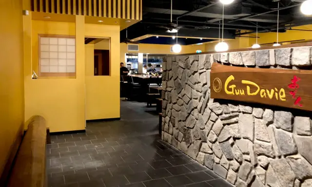 Yellow entrance corridor and stone wall inside Guu Davie.