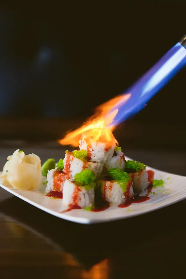 Sushi rolls being finished with a culinary torch at Hapa Izakaya.