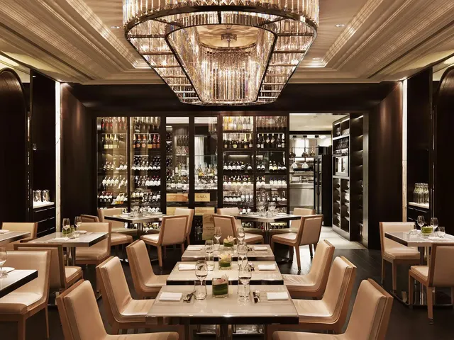Hawksworth's Pearl Room, with a large chandelier, cream dining chairs and glass-fronted wine cabinets.