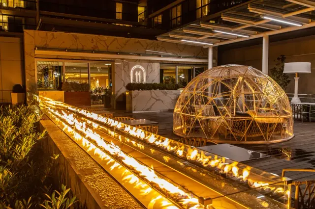 An outdoor fire feature and domed dining enclosure at H Tasting Lounge.