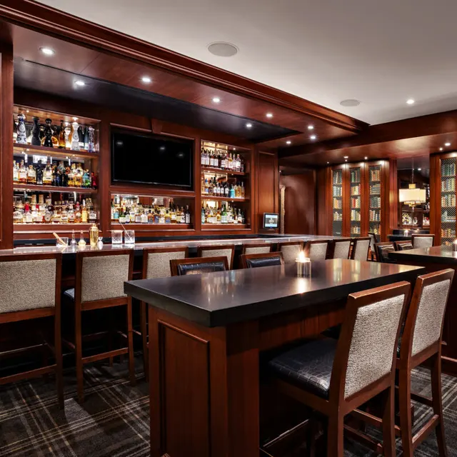Wood-panelled bar, bottle shelves and high-backed chairs at Hy's Steakhouse in Vancouver.