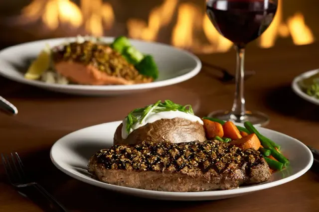 Steak and side dishes in an official photograph from The Keg.