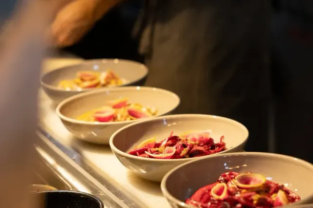 Plated dishes lined up at the kitchen counter at La Mezcaleria.