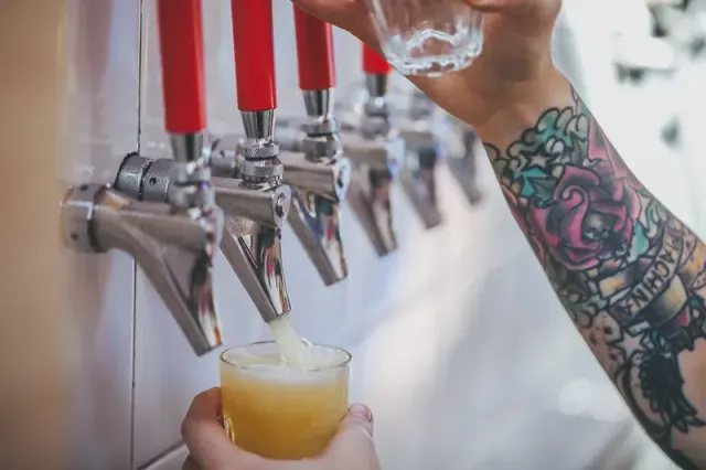 Beer being poured from a tap into a glass.