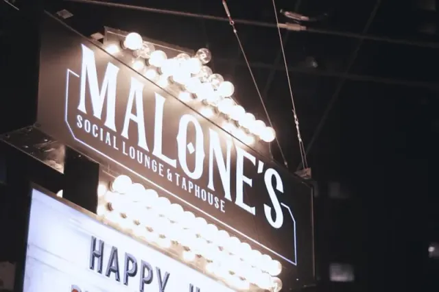 Illuminated Malone’s Taphouse sign on the venue exterior.