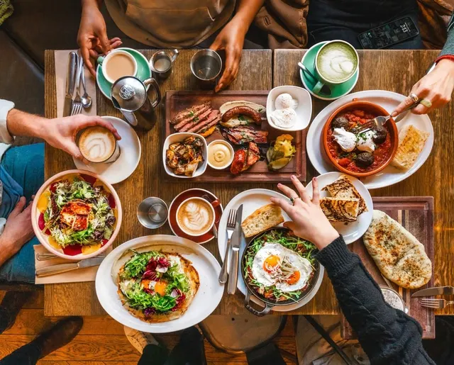 Brunch dishes, coffee and shared plates covering a table at Medina Cafe.