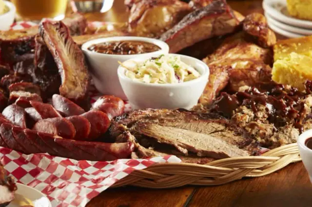 Barbecue meats and side dishes arranged on a platter.