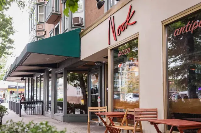 Nook restaurant frontage with a green awning and outdoor tables.