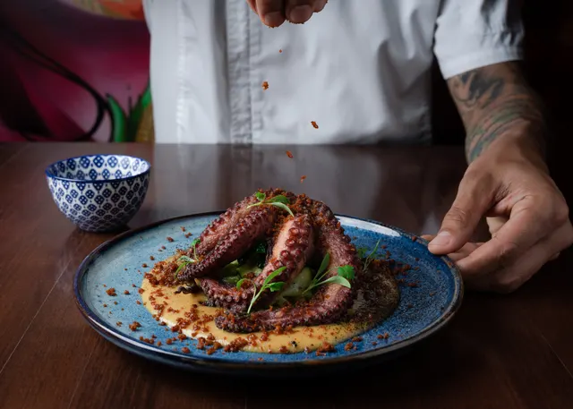 A chef finishing a plate of octopus at Ophelia.