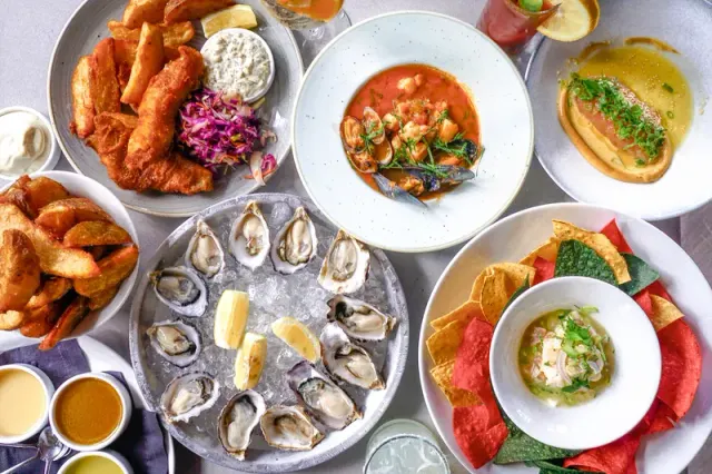 A spread of oysters and plated seafood dishes.