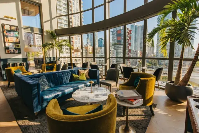 Lounge seating and tables beside tall windows.