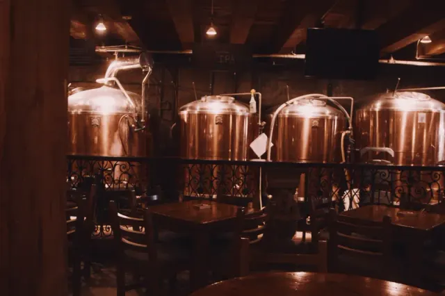 Copper brewing tanks inside a warmly lit brewpub.