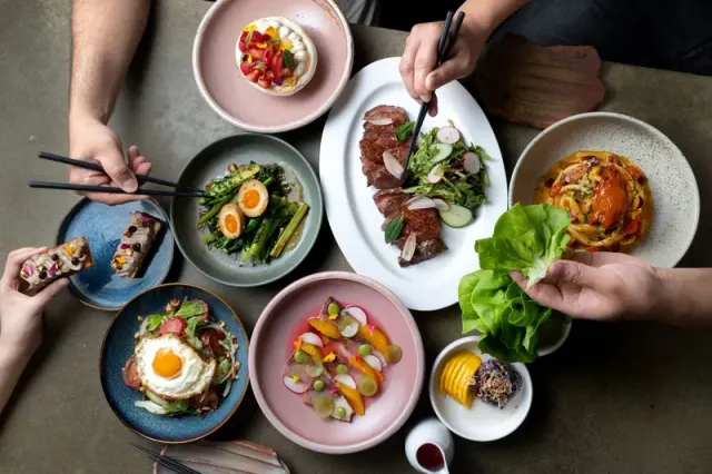 Several plated dishes shared around a restaurant table.