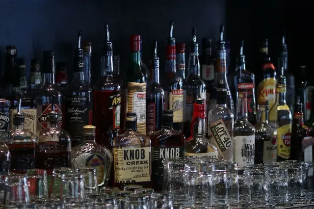Bottles and glassware arranged behind a bar.