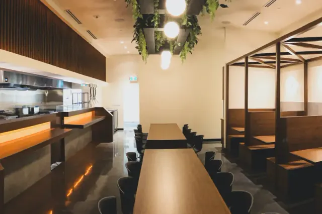 Restaurant interior with a long communal table and wooden booths.