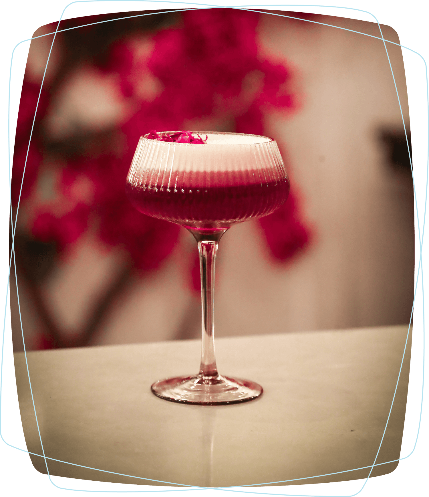 A ruby-red cocktail with a pale foam top in a stemmed glass, pictured on Cavo's website.