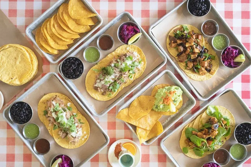 Tacos, tortilla chips and bowls of salsa on a table at Chancho.