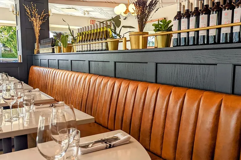 Set tables along the leather banquette at Coquette Brasserie.