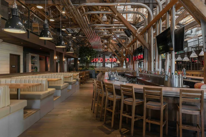Bar seating and tables beneath exposed beams at Craft Beer Market False Creek.