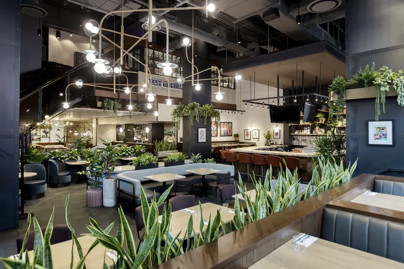 Tables, booths and plants inside Earls Test Kitchen.