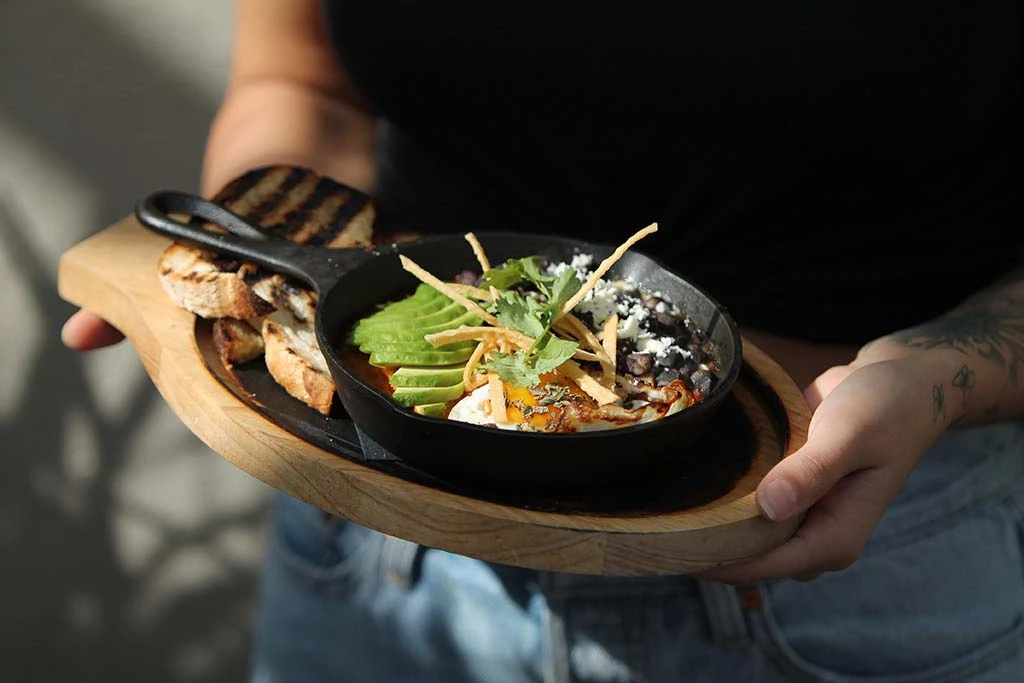 A skillet meal with avocado and toast at El Guapo.