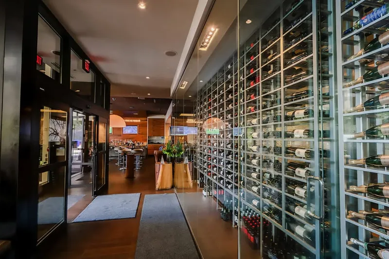 The entrance corridor and glass-fronted wine storage at JOEY Burrard.