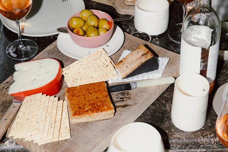 Cheese, crackers, olives and wine on a table at La Fabrique St-George.