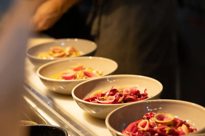 Plated dishes lined up at the kitchen counter at La Mezcaleria.