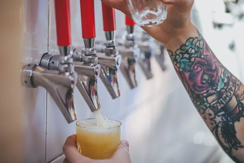 Beer being poured from a tap into a glass.