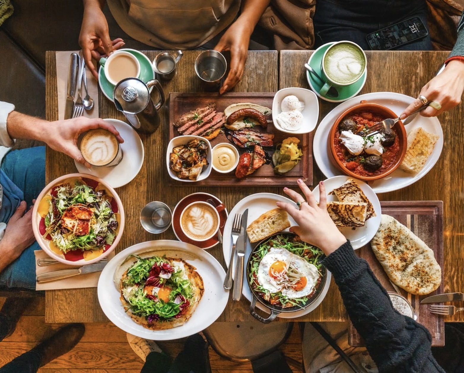 Brunch dishes, coffee and shared plates covering a table at Medina Cafe.