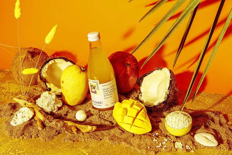 Bottles and drinks arranged among citrus fruit.