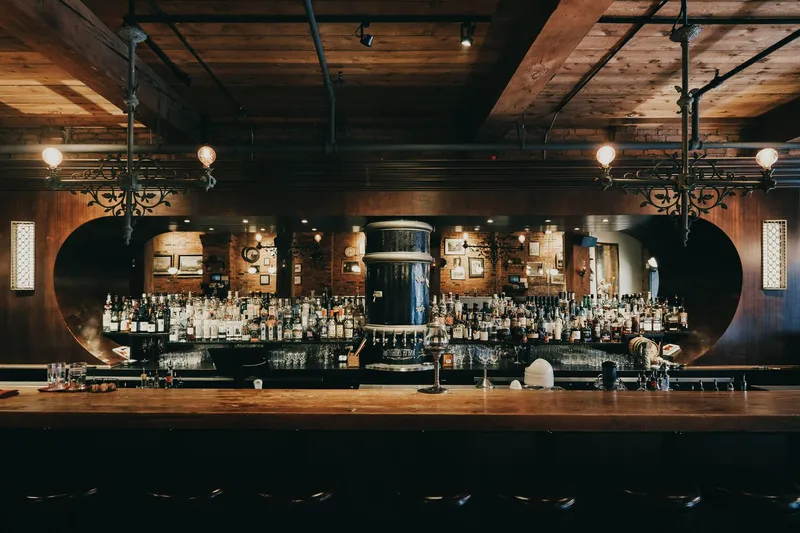 Restaurant bar with brickwork, bottle shelves and warm lighting.