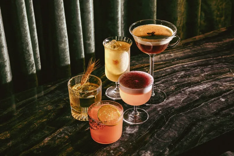 Several cocktails arranged on a dark tabletop.