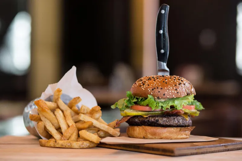 A burger and fries served on a board.