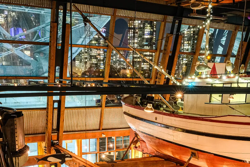 Timber-framed restaurant interior with large windows and a decorative boat.
