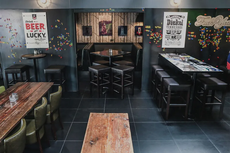 Pub interior with wooden tables, chairs and wall art.