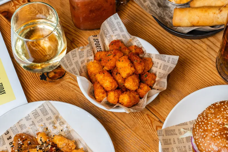 Pub dishes and a drink arranged on a wooden table.