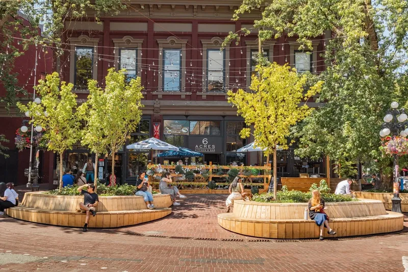 Brick restaurant building with outdoor seating and trees.