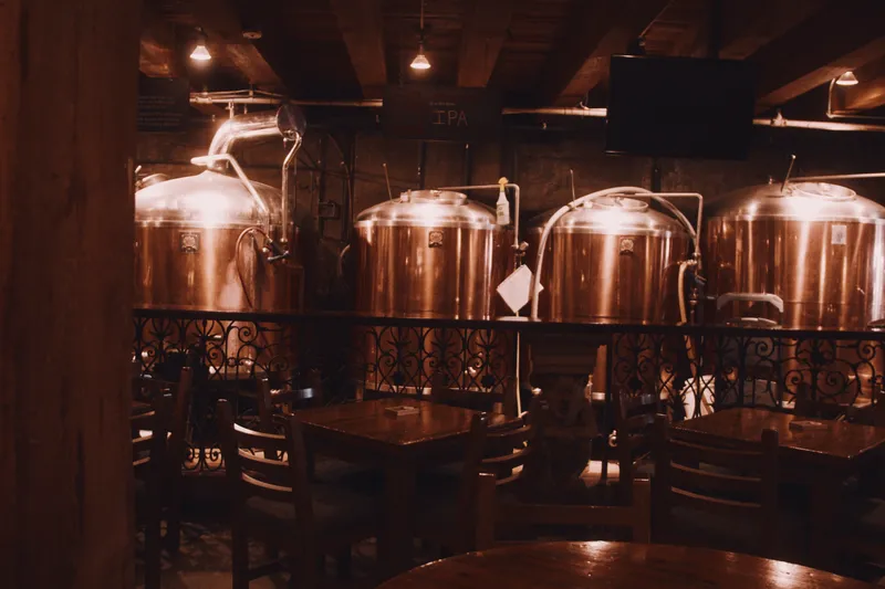 Copper brewing tanks inside a warmly lit brewpub.